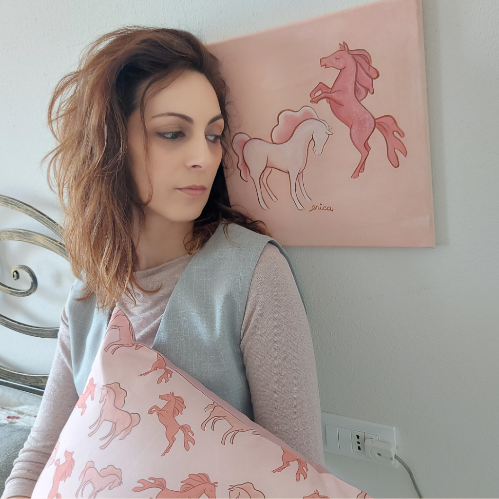sono io mentre osservo il mio quadro di cavalli di vetro di murano che poi ho fatto diventare un pattern design tessile su un cuscino di arredamento